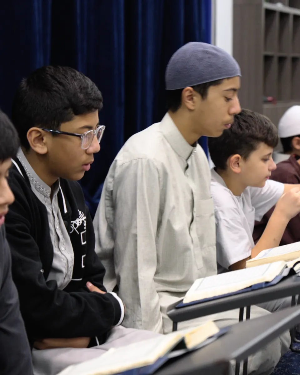 Students reading the Qur’an side by side at their desks