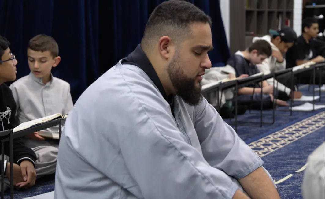 A teacher reciting alongside his students